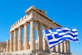 World famous iconic Parthenon on the Acropolis Hill in Athens, Greece with Greek flag against blue sky Royalty Free Stock Photo