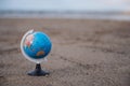 World globe ball on sand beach with sea background, Blue world map on lawn with copy space for text,World environment day Royalty Free Stock Photo