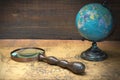 World Globe And Magnifier On The Old Map Royalty Free Stock Photo