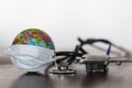 World globe with medical face mask on and medical stethoscope and airplane on wooden table