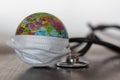 World globe wearing medical face mask and medical stethoscope