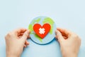 World health day concept. Female hands hold a paper model of the globe with a heart Royalty Free Stock Photo