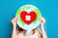 World health day concept. Female hands hold a paper model of the globe with a heart Royalty Free Stock Photo