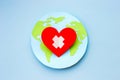 World health day concept. Paper model of earth globe, heart with cross on blue background Royalty Free Stock Photo