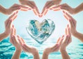 World heart day and environmental protection concept with love earth in community volunteer`s hands. Royalty Free Stock Photo