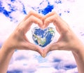 World in heart shape with over women human hands. Royalty Free Stock Photo