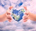 World in heart shape with over women human hands. Royalty Free Stock Photo