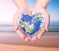 World in heart shape with over women human hands. Royalty Free Stock Photo