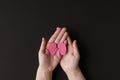 World kidney day. Adult hands holding kidney shaped paper on black background. National Organ Donor Day. Kidney health concept Royalty Free Stock Photo