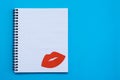 World Kiss Day. Red lips on a blank sheet of open notebook on a blue background