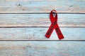 World Malaria Day, April 25, healthcare and medical concept, red ribbon on the blue wooden background