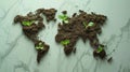 World map created out of a soil, with seedlings beginning to grow