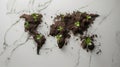 World map created out of a soil, with seedlings beginning to grow