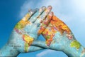 World map in hands against the sky Royalty Free Stock Photo
