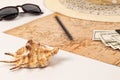 World map, straw hat, black leather wallet with money, sunglasses, pencil and shell on a wooden table Royalty Free Stock Photo