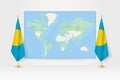 World Map between two hanging flags of Palau flag stand Royalty Free Stock Photo