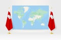 World Map between two hanging flags of Tonga flag stand Royalty Free Stock Photo