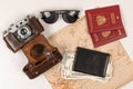 World map, two passports, money in a black leather wallet, an old film camera in a leather case and sunglasses on a white wooden t Royalty Free Stock Photo