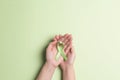 World mental health day concept. Green awareness ribbon in female hands on a green background