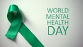 World mental health day inscription, green ribbon on table, awareness campaign