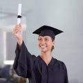 The world is now her oyster. a young woman in a graduation gown holding up her diploma and looking at it. Royalty Free Stock Photo