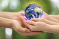 World in our hands. Closeup view of parents and kid holding digital model of Earth on blurred green background, space for text Royalty Free Stock Photo