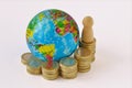 World planet and raising coins stack with pawn - Concept of global economy Royalty Free Stock Photo