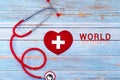 World Red Cross day. Red heart with Stethoscope on wooden table background