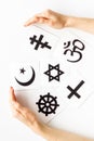 World religions concept. Hands hugs Christianity, Catholicism, Buddhism, Judaism, Islam symbols on white background top