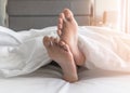 World sleep day, sleeping comfort relaxation and bedtime insomnia concept with young girlÃ¢â¬â¢s bare foot laying lazy on bed resting