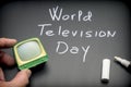 World Television Day written on Blackboard next to miniature TV
