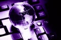 World transparent globe earth on computer keyboard. Global communications business concept. Ultraviolet colored Image. Color of th Royalty Free Stock Photo