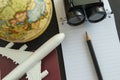 World travel concept with toy airplane, pencil binoculars, passport, note and globe on black background Royalty Free Stock Photo