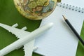 World travel concept with toy airplane, pencil note and globe on