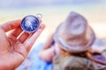 Travel around the world: compass in foreground, beautiful girl with straw hat lying on the beach in the background