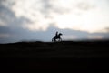 World war officer (or warrior) rider on horse with a sword ready to fight and soldiers on a dark foggy toned background. Battle Royalty Free Stock Photo