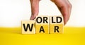 World war symbol. Concept words World war on wooden cubes. Businessman hand. Beautiful yellow table white background. Business and Royalty Free Stock Photo