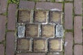 World War Two. Stumbling stones, or stolpersteine are memorial brass plates placed into the pavement outside certain houses