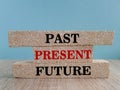 Worlds present past and future on brick blocks. Beautiful blue background, wooden table. To focus on the current situation,