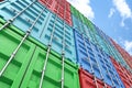 Worm`s eye view of 3d rendered colorful shipping containers stacked on one another making a wall that goes up in blue