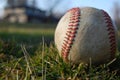 A worn baseball in the grass