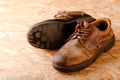 Worn brown leather boots on OSB board Royalty Free Stock Photo