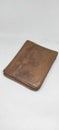 A worn brown wallet in a man's hand, an empty wallet, a worn brown leather wallet,