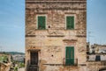 Worn byzantine building facade in Italy with old louvered shutters or louvres and decadent exterior. Neighbourhood illutration Royalty Free Stock Photo