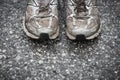 Worn, dirty, smelly and old running shoes on a tarmac road Royalty Free Stock Photo
