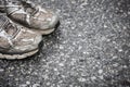 Worn, dirty, smelly and old running shoes on a tarmac road