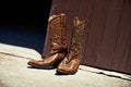 Worn in by hard work. Shot of a pair of cowboy boots outside a barn. Royalty Free Stock Photo