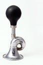 A worn iron horn or klaxon from a vintage car or bicycle lies horizontally. Isolated on a light background with a shadow. Royalty Free Stock Photo