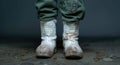 Worn military boots on muddy ground