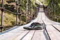 Worn old men`s shoes on a suspension bridge over the river